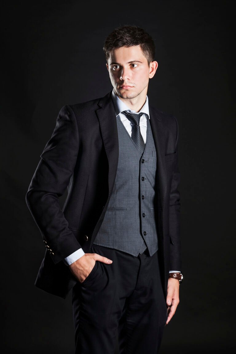 confident-businessman-standing-against-black-background
